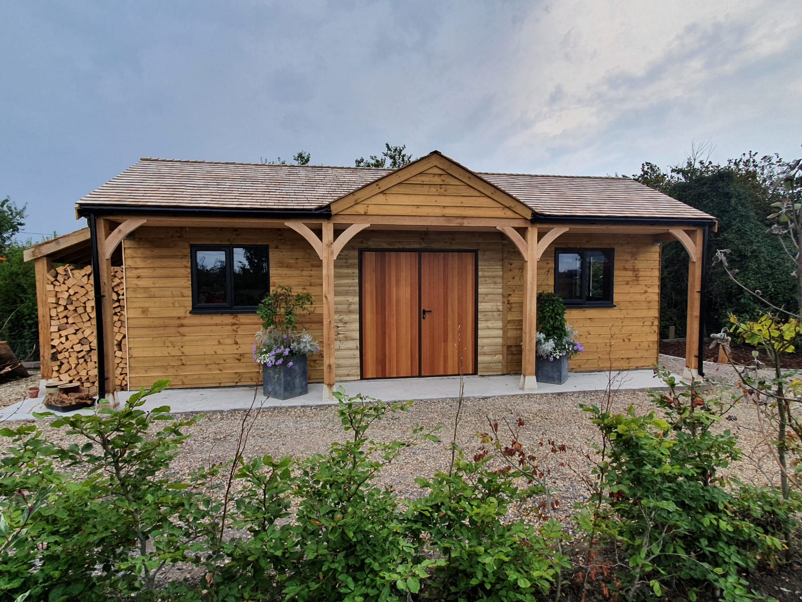 Bespoke Garage with Cedar Shingle Roof, UPVC Anthracite Windows, and Cedar-wood Doors