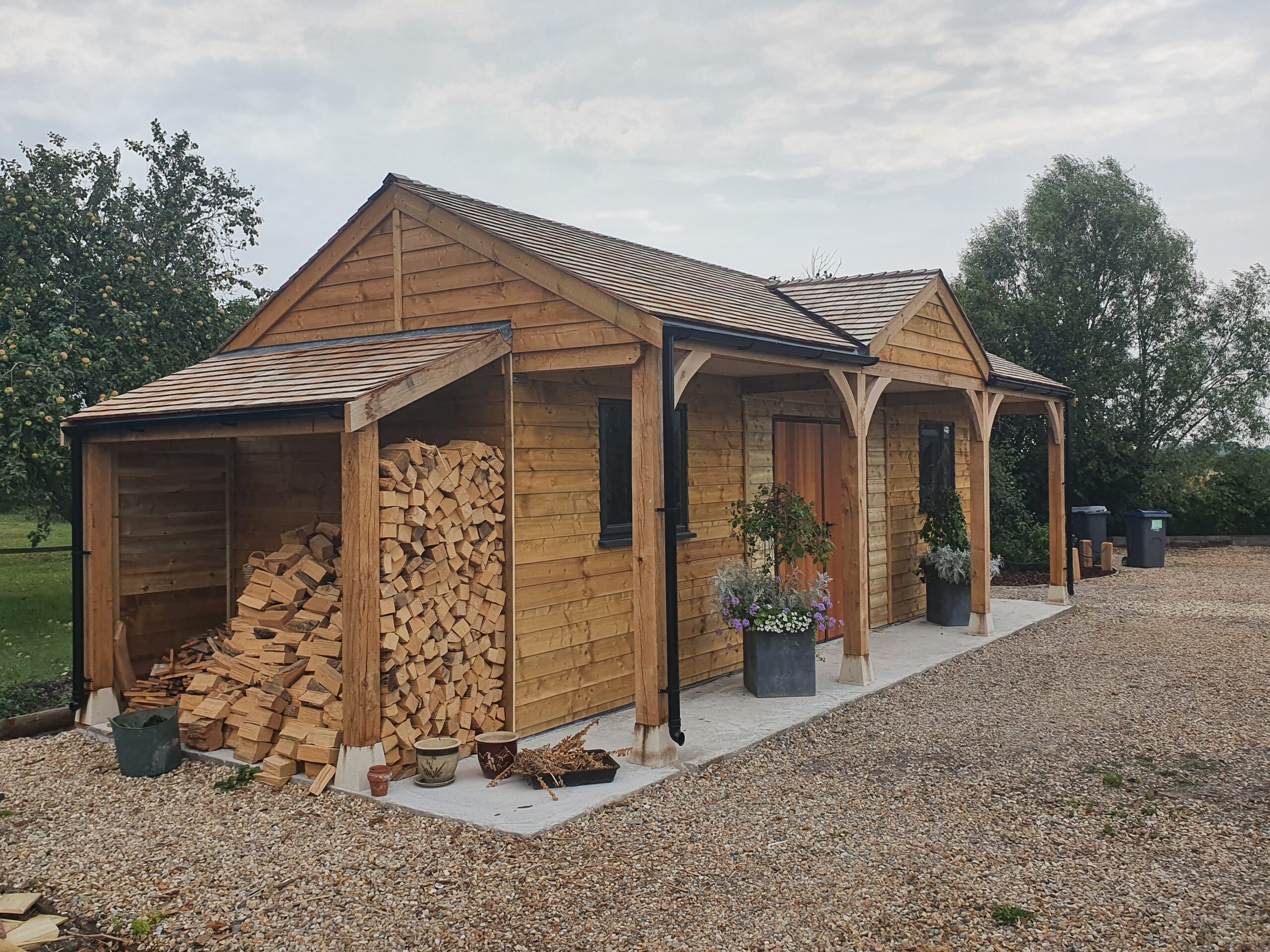 Bespoke Garage with Cedar Shingle Roof, UPVC Anthracite Windows, and Cedar-wood Doors